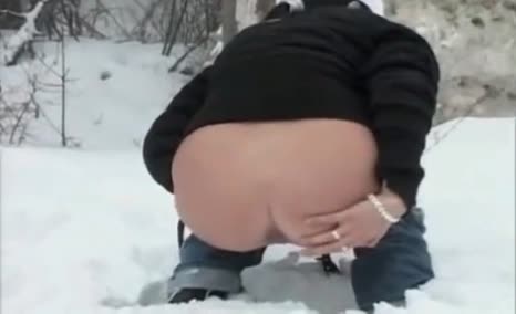 Horny milf is pooping in the snow